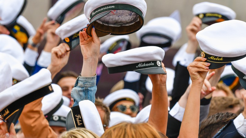 Studenterna lyftar sina mössor.