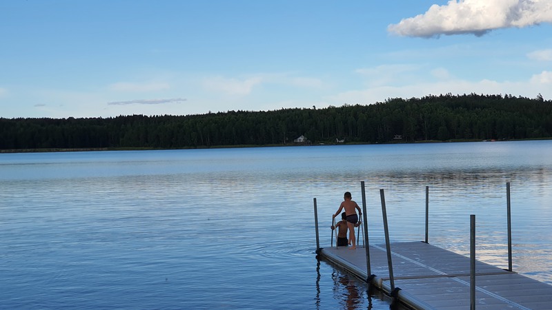 Två barn som badar från en brygga i Norra viken, Vänern.
